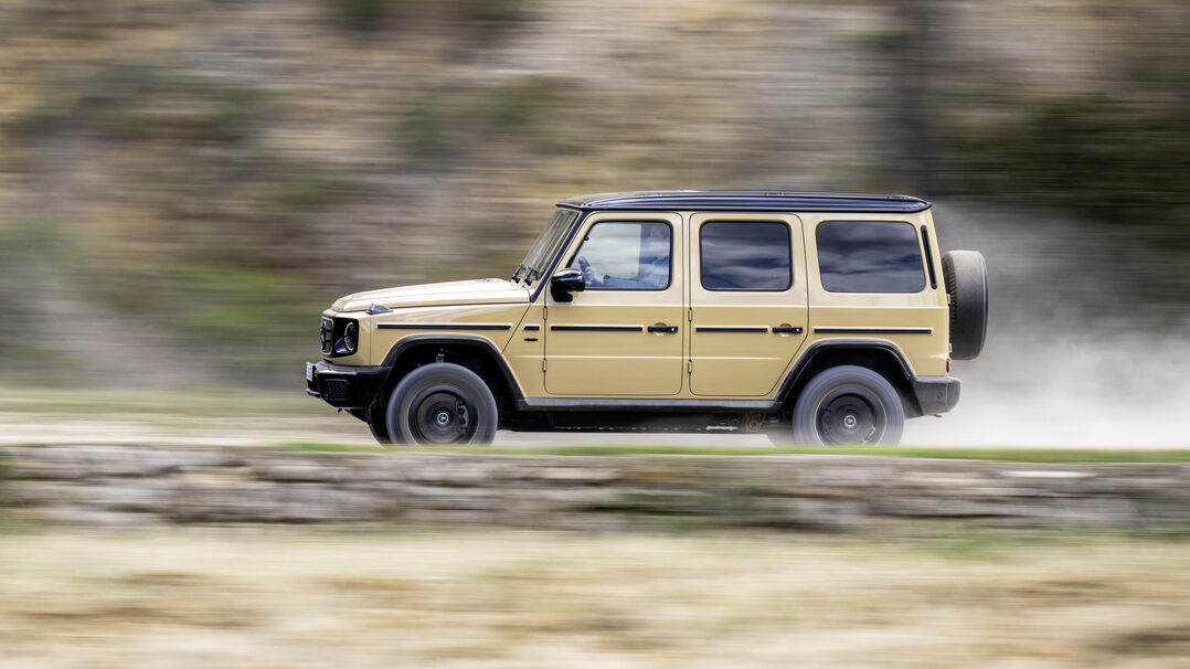 Tan Mercedes G-Class on road, left side profile