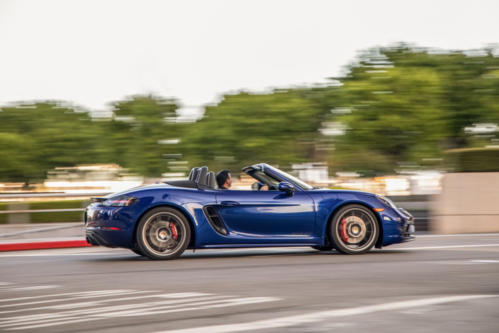 Blue Porsche 718 Boxster on road