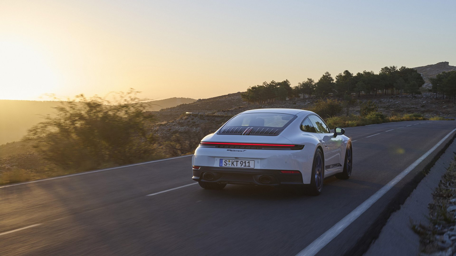 White Porsche 911 Carrera T on road, right rear